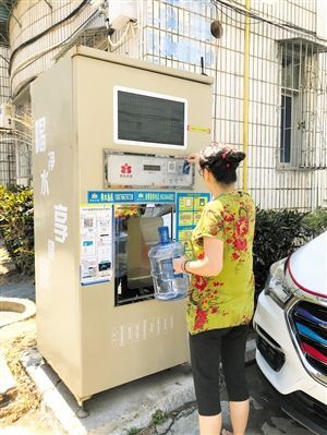 5月24日，瓊山區上丹花苑小區居民陳女士在使用共享凈水機取水。 本報記者 陳歆卓 攝